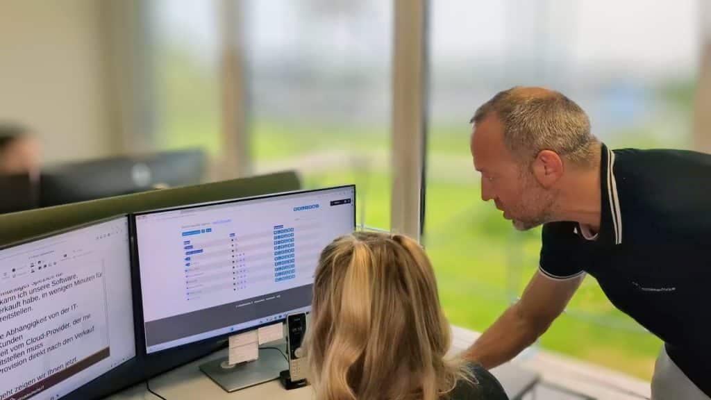 Zwei Persomem schauen sich gemeinsam den SaaS-Manager an